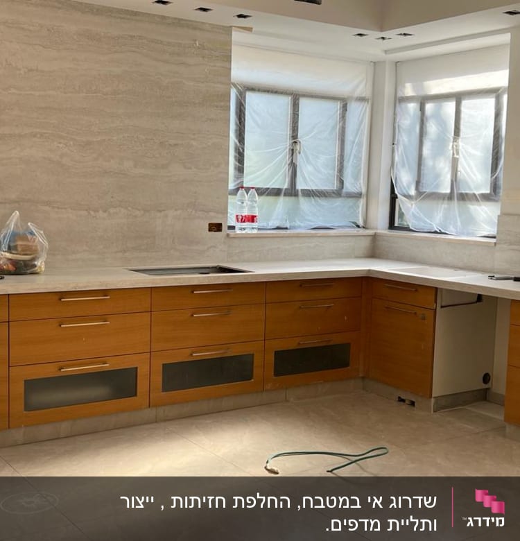 מטבח עם ארונות עץ, כיור וכלים על השיש